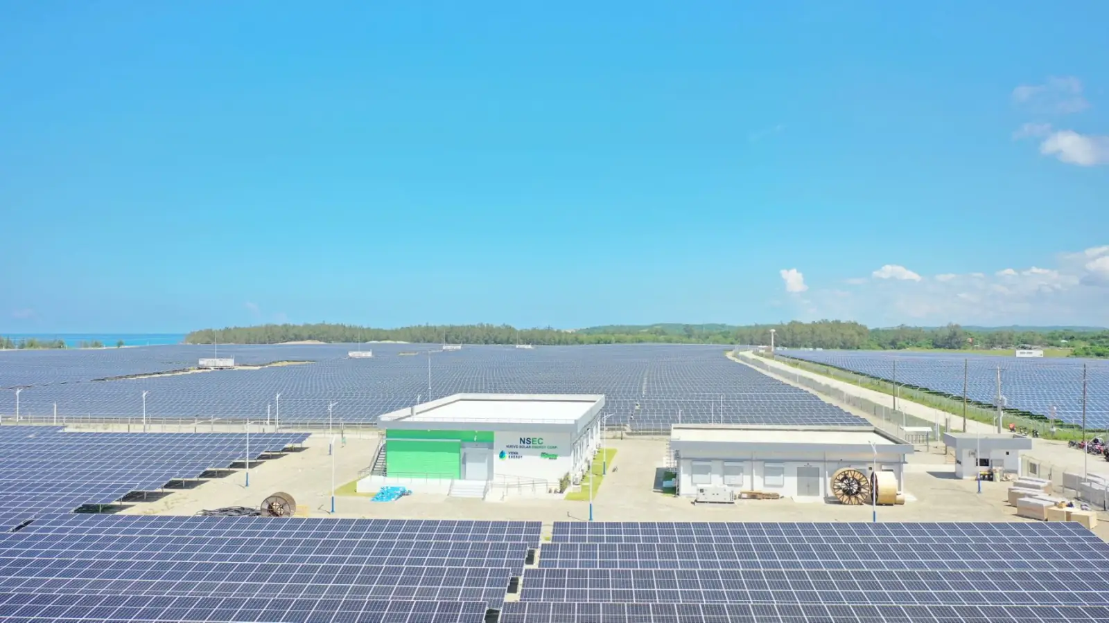 Aerial of a vast utility-scale solar panel field stretching toward the horizon